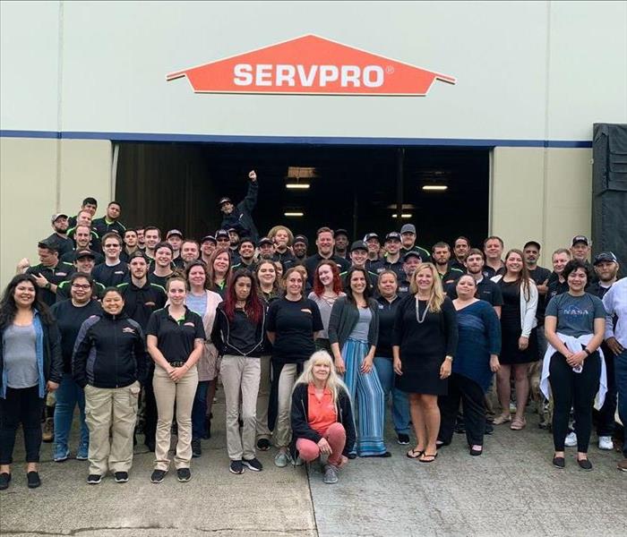 Servpro staff stand together in front of the warehouse